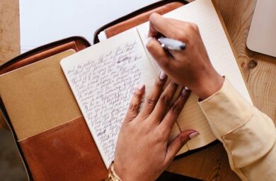 Woman's hand writing on a notebook